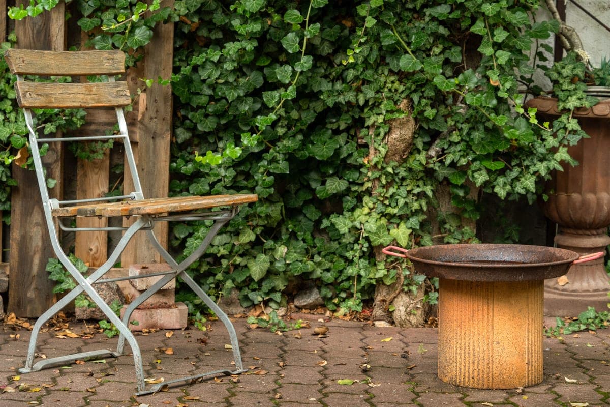 A steel fire pit with a weathered rust-colored finish