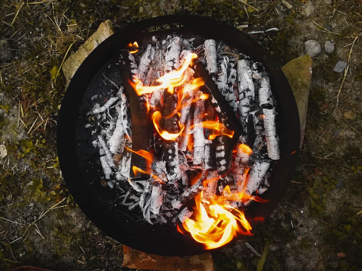 Wood burning in a round steel pan outdoors
