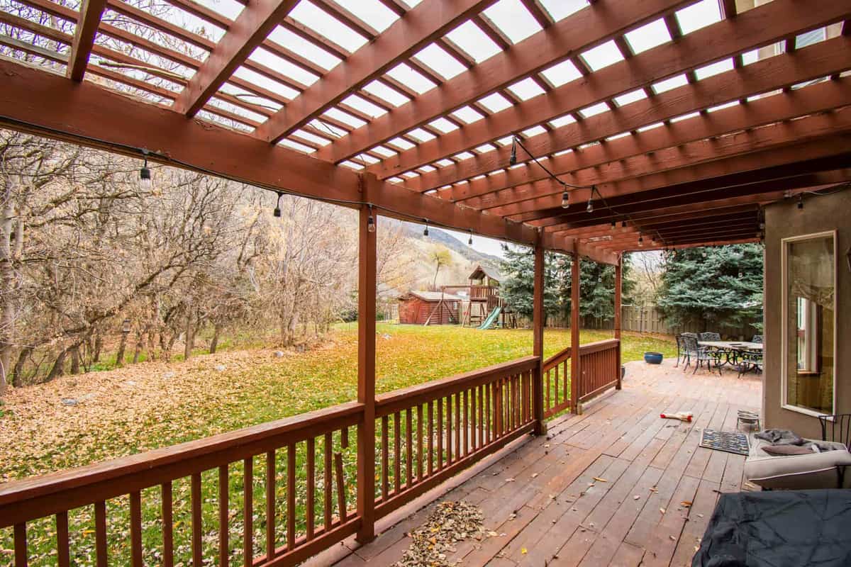 A covered porch with fallen leaves