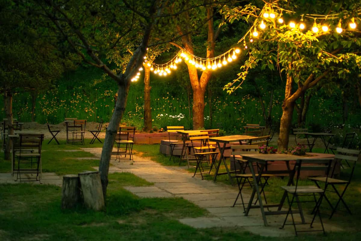 An outdoor dining area lit with string lights at night