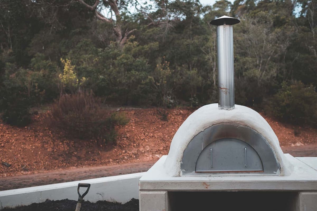 A stone outdoor fireplace with a flue