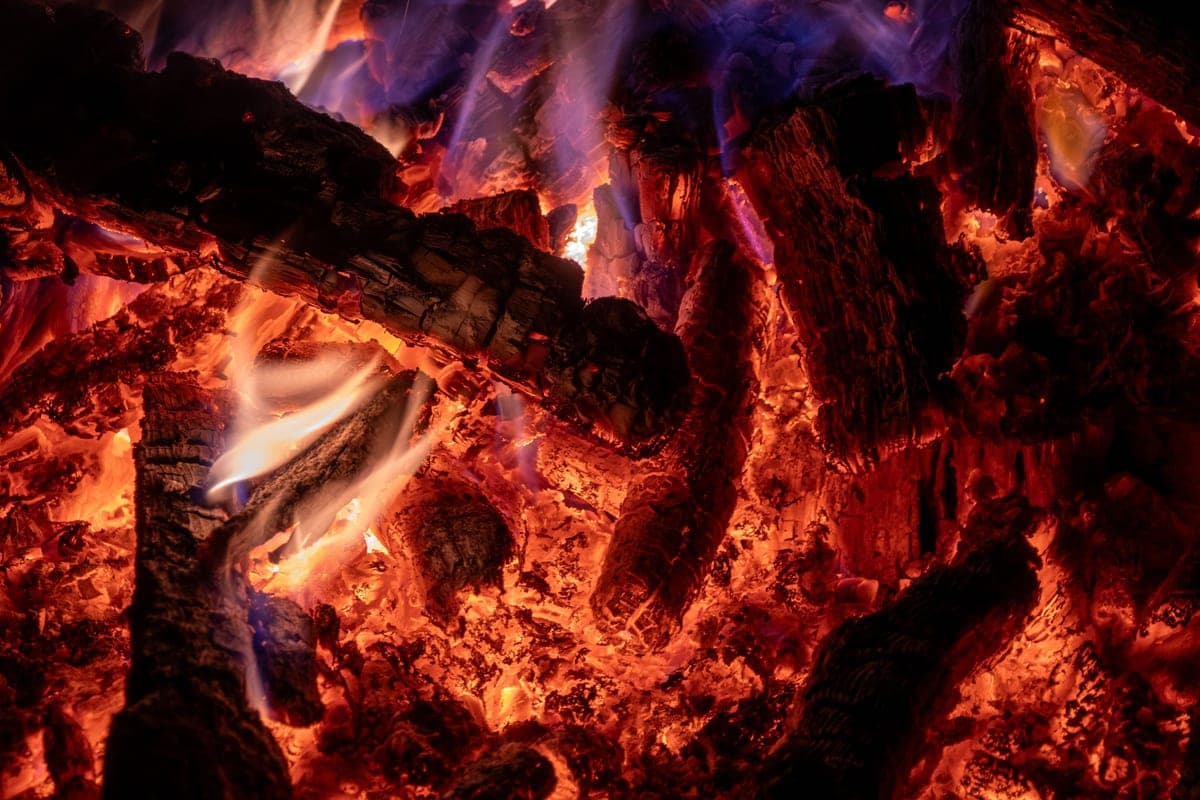 Intense orange flames rising from burning logs