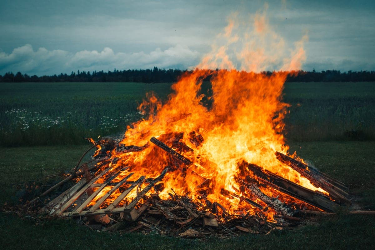 A large bonfire burning on open grassland