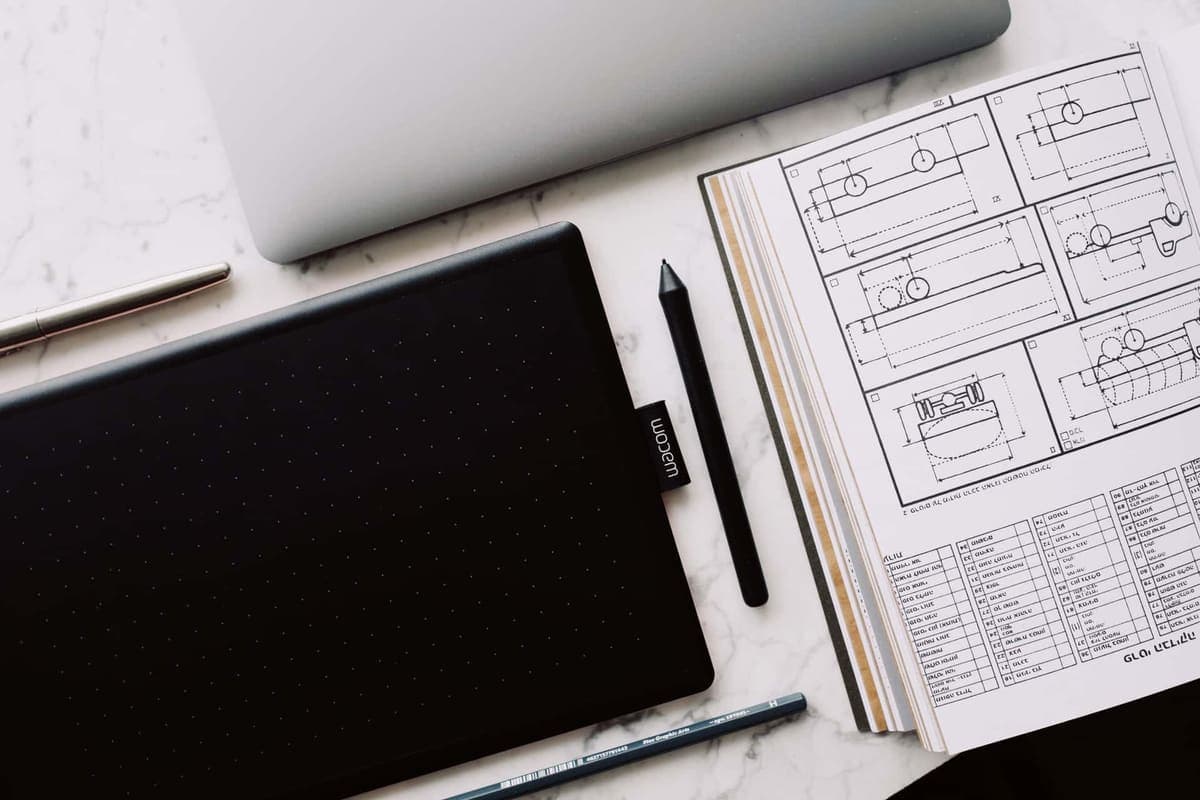 An open notebook and a tablet on a desk