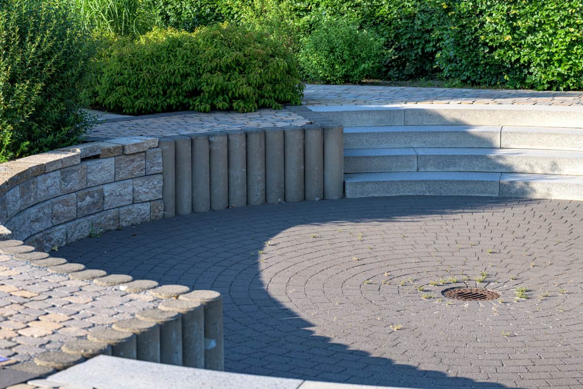 A circular stone patio with built-in seating at dusk