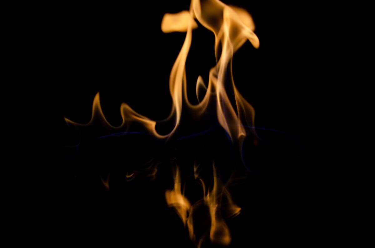 Flames burning above a dark reflective surface