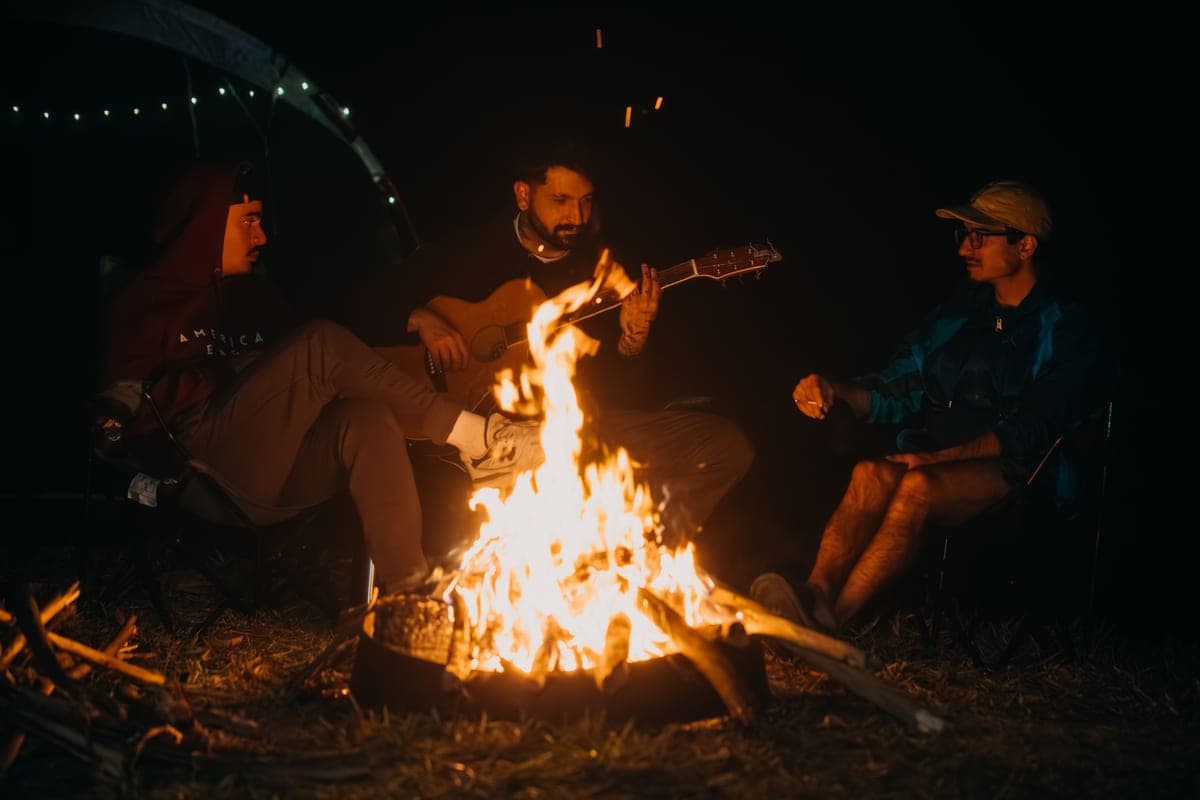 People gathered around a small outdoor fire at night